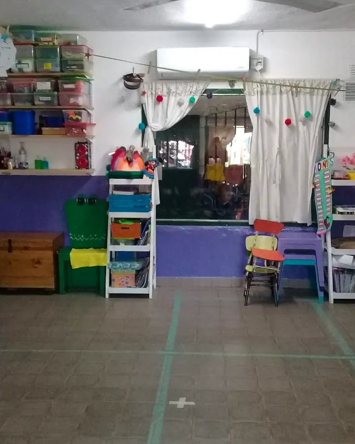Una sala por dentro, con estantes de juegos y cortinas